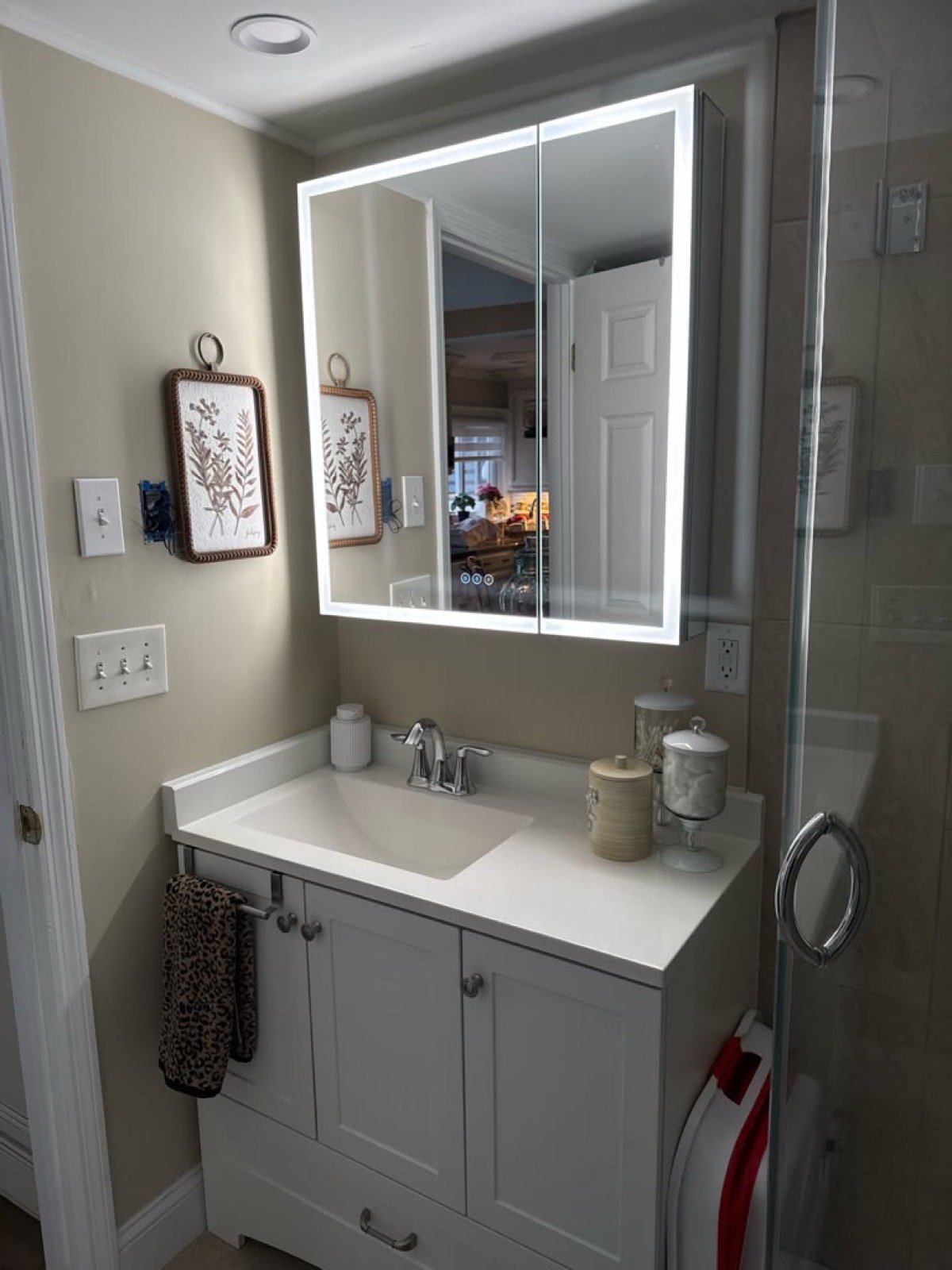 White bathroom vanity with a backlit LED medicine cabinet
