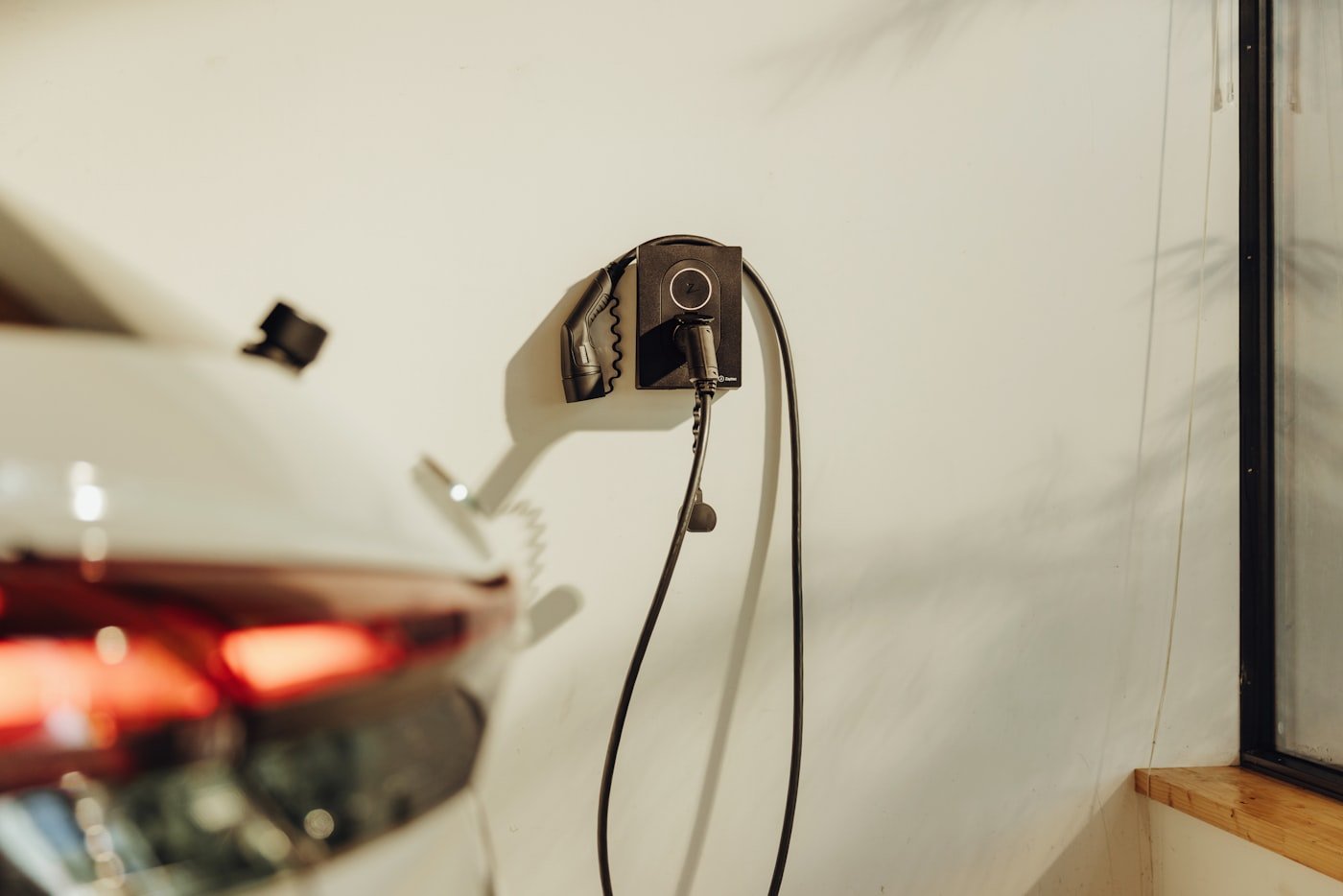 Wall-mounted EV charger plugged into an electric car