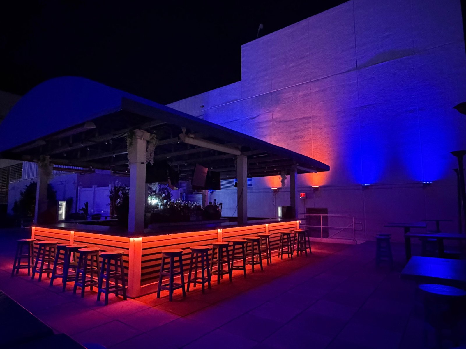Rooftop bar glowing warm amber under the canopy at night