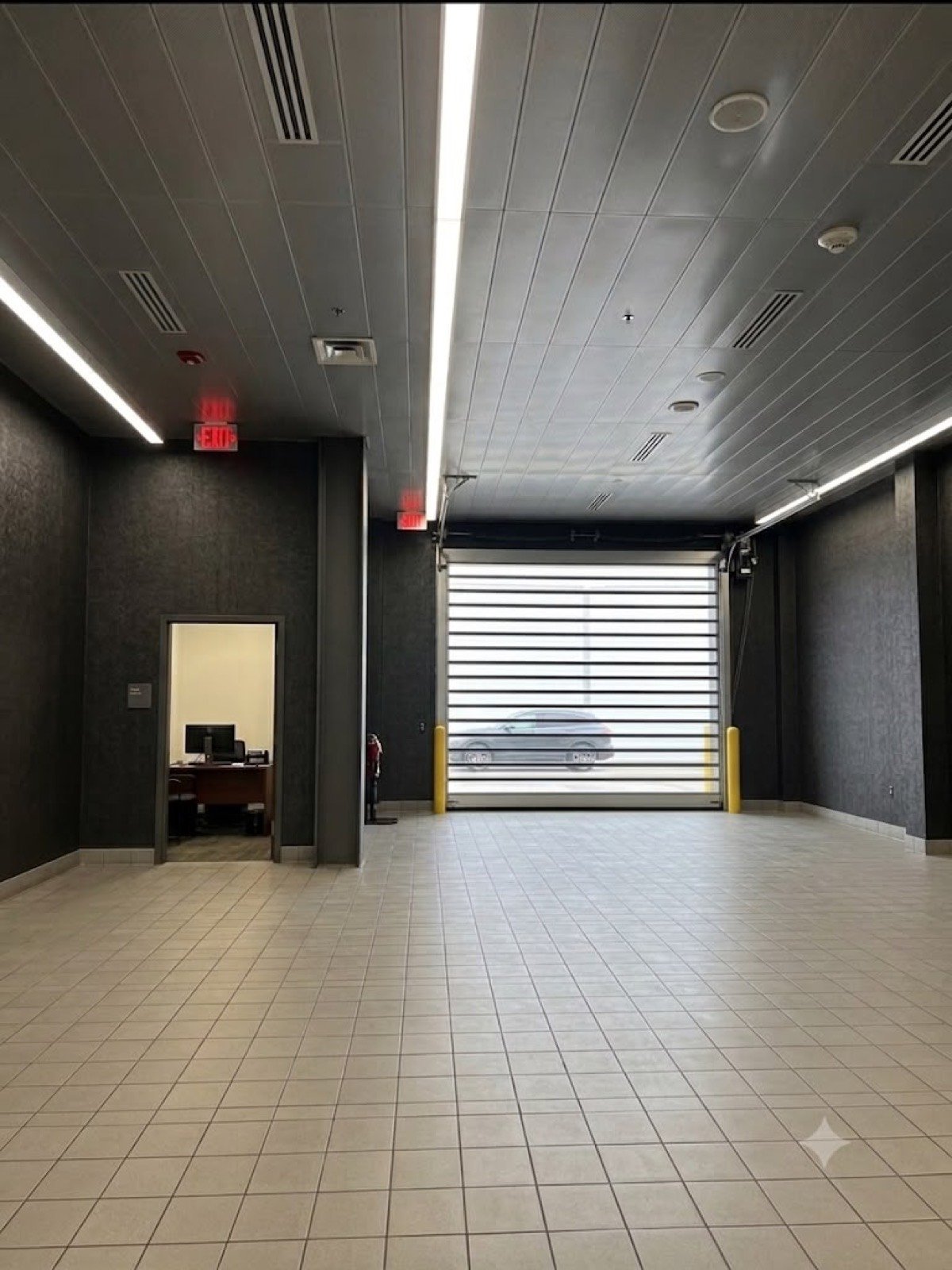 Commercial service bay with LED lighting and a high-speed door, wired by J.B.R.