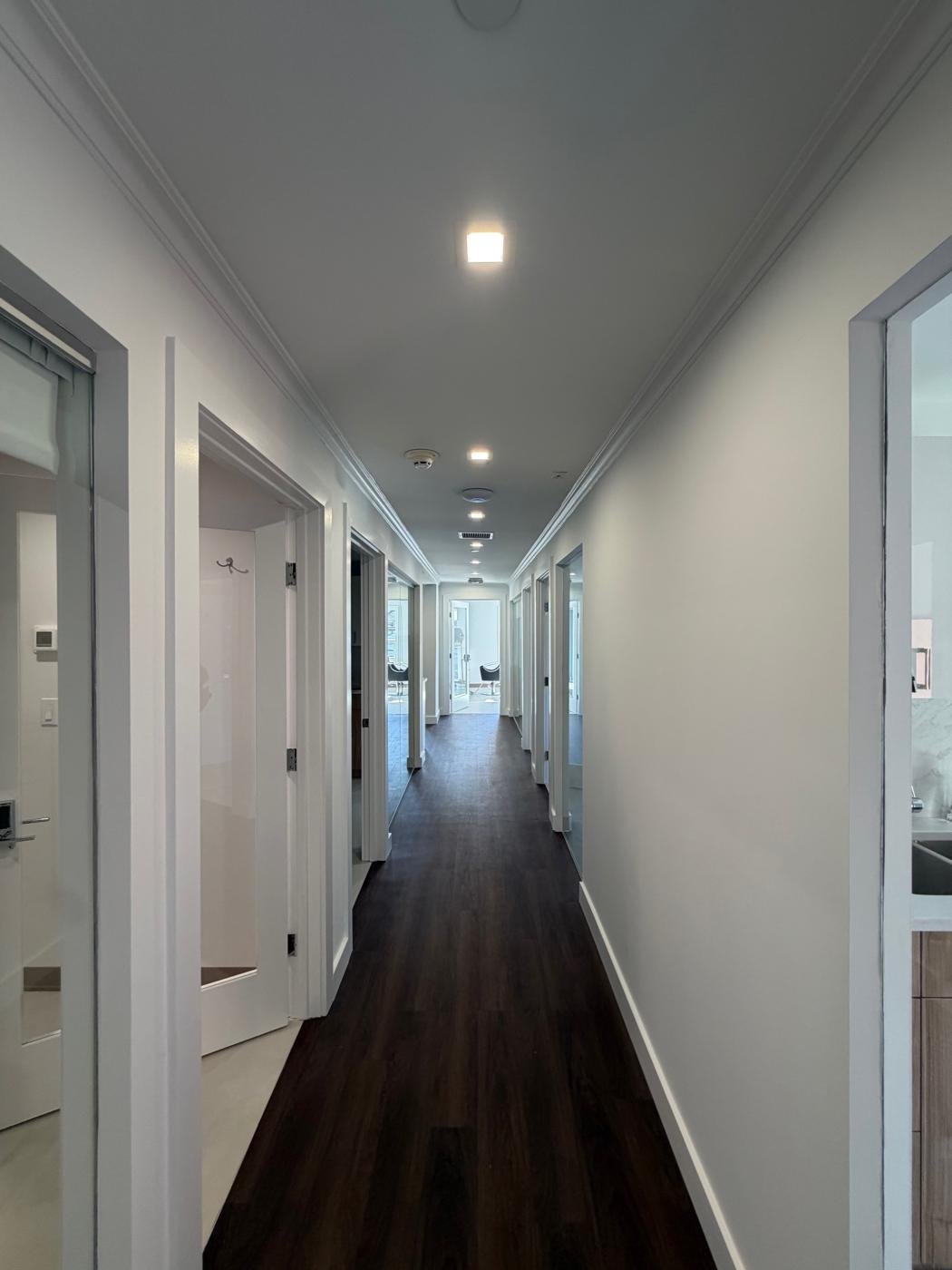 Bright salon corridor with a straight run of recessed ceiling lights