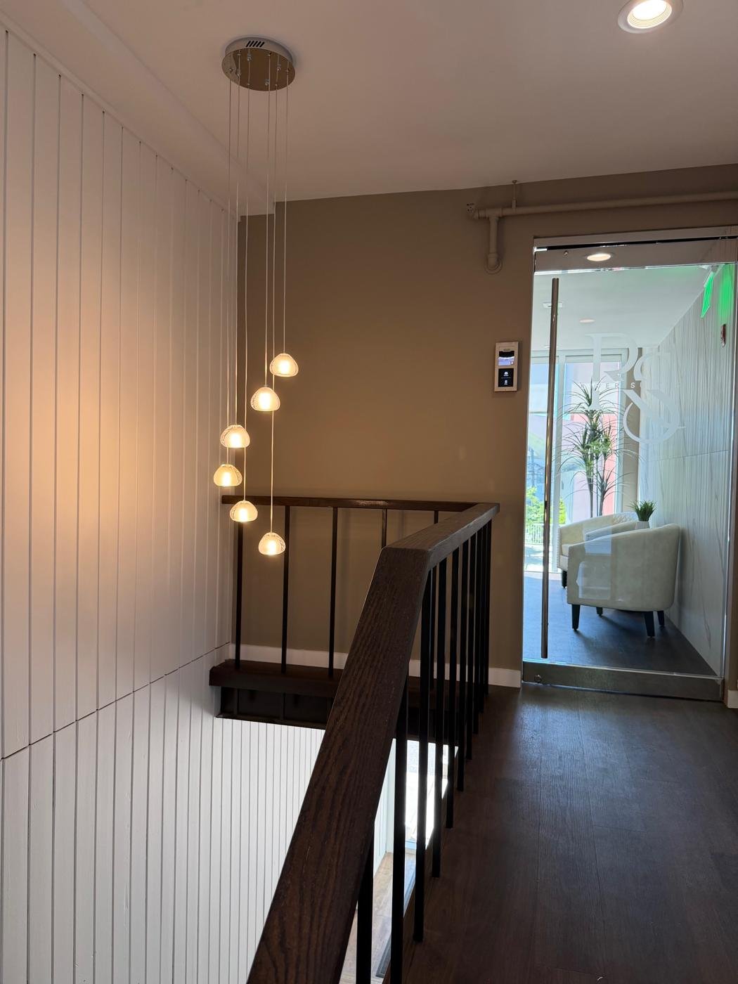 Cascading pendant light fixture installed by J.B.R. over a home staircase